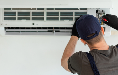 Technician installing new AC unit in a residential home with proper measuring and leveling